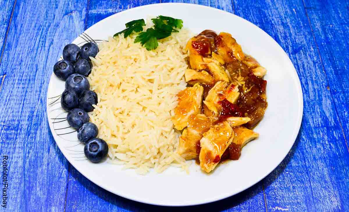 Foto de un plato con pollo arroz y arándanos que revela las recetas de pechuga de pollo fáciles y rápidas