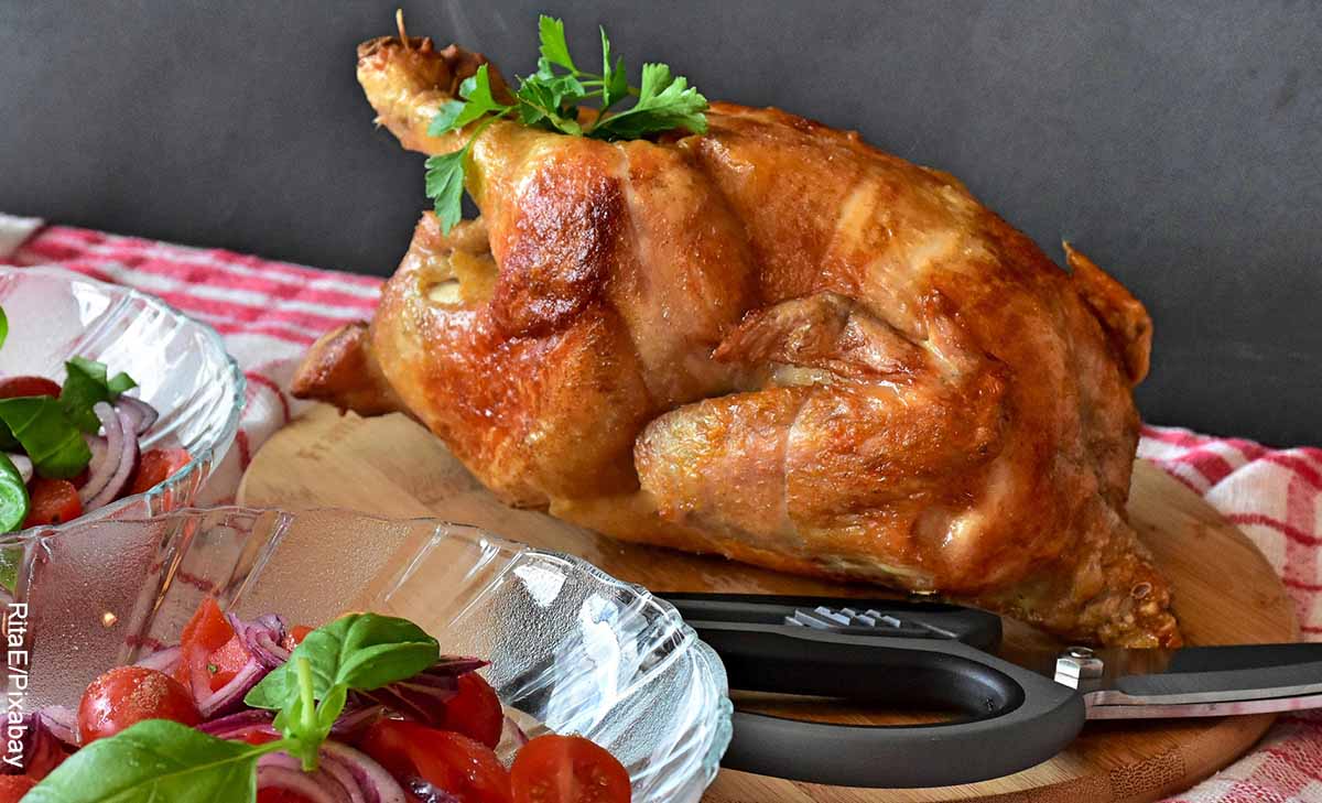 Foto de un pollo asado y ensalada sobre una mesa que revela las recetas de pollo
