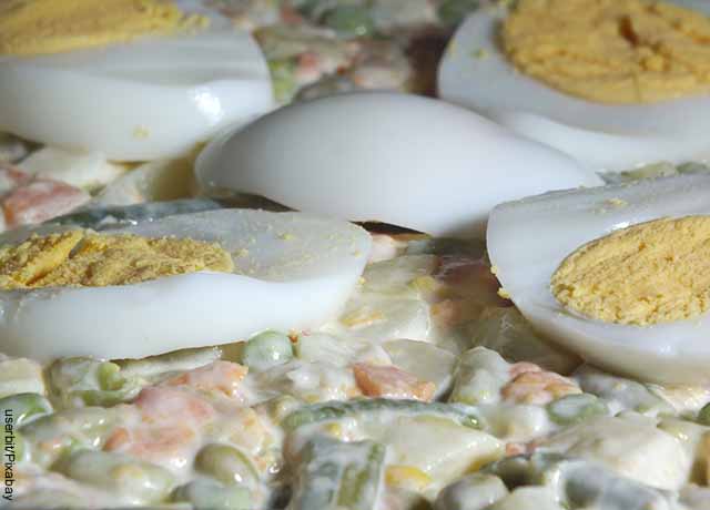 Foto de ensalada rusa con huevo duro encima
