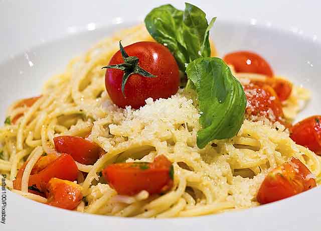 Foto de pasta con tomate y queso en un plato