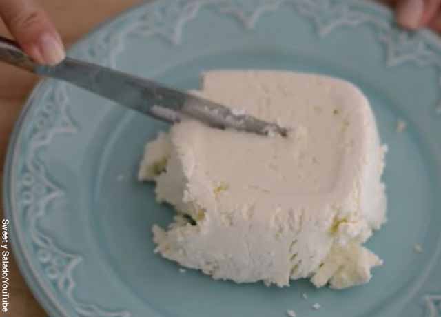 Foto de un bloque de queso partido por un cuchillo