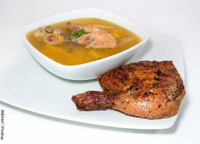 Foto de un plato de sopa de pollo y una presa de pollo asada