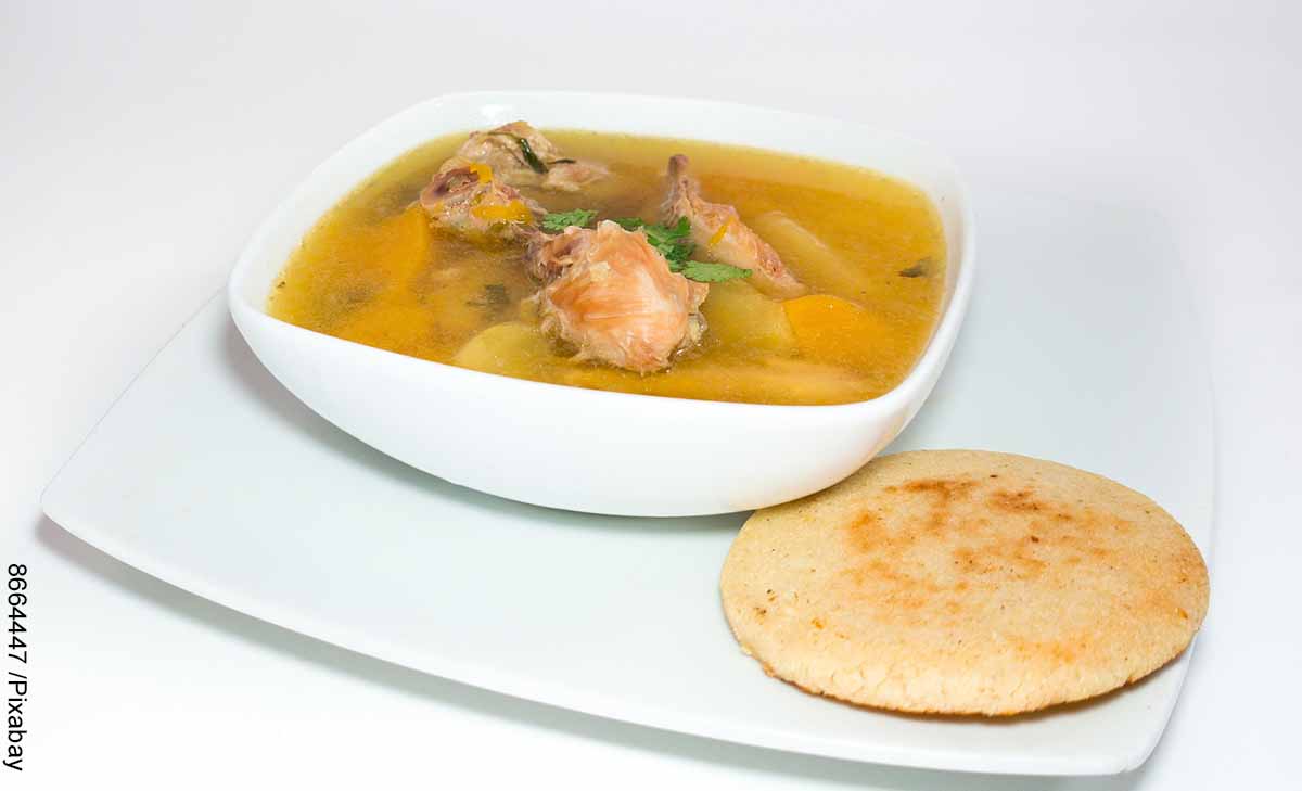 Foto de un plato de sopa con papa y una arepa que muestra cómo hacer sopa de pollo