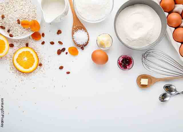 Foto de naranja, huevos, azúcar y harina sobre la mesa