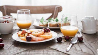 Foto de un desayuno en la mesa con jugo y frutas que revela cómo hacer un desayuno sorpresa para hombre