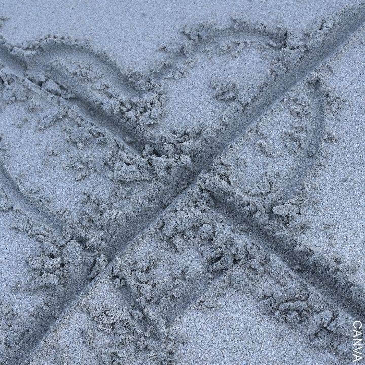Foto de un corazón tachado dibujado en la arena