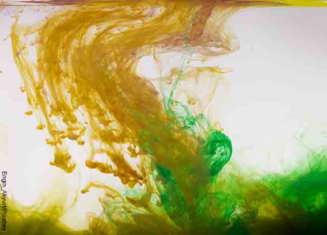 Foto de tinta de colores cayendo en agua que revela lo que es soñar con agua sucia