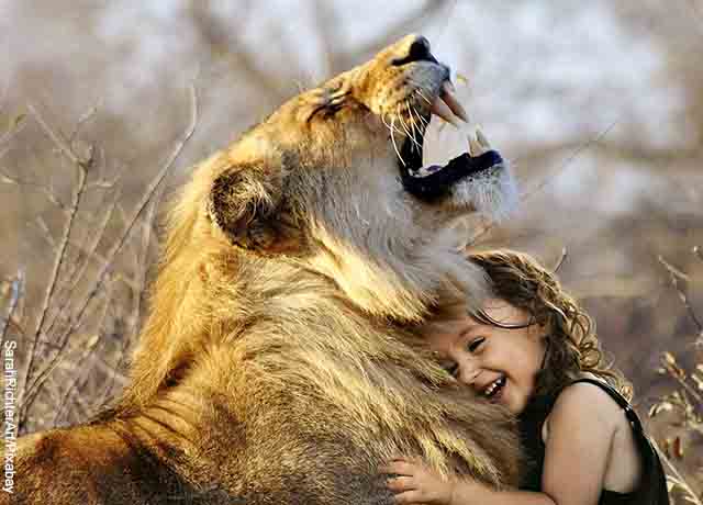 Foto de un león con una niña que revela lo que es soñar con leones