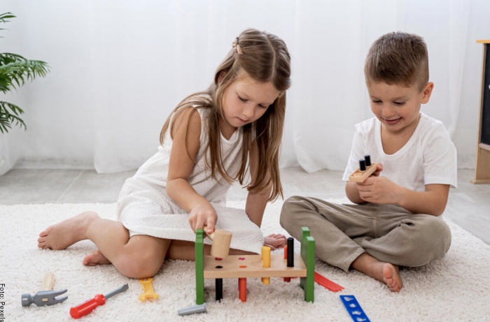 Foto de dos niños jugando con herramientas de juguete