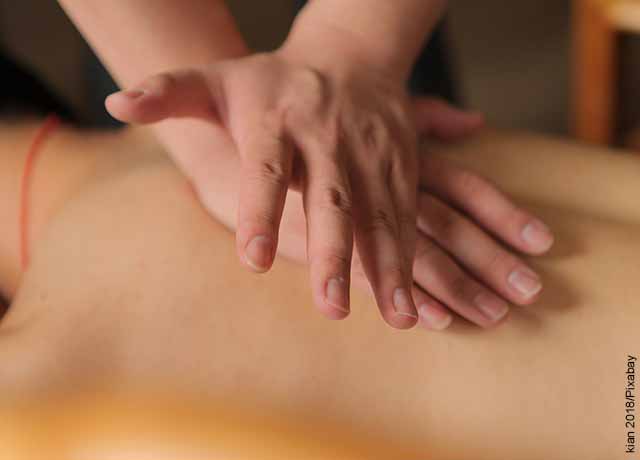 Foto de una mujer a la que le masajean su espalda que muestra el masaje linfático
