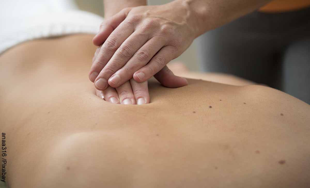Foto de una persona presionando la espalda de otra que revela el masaje linfático