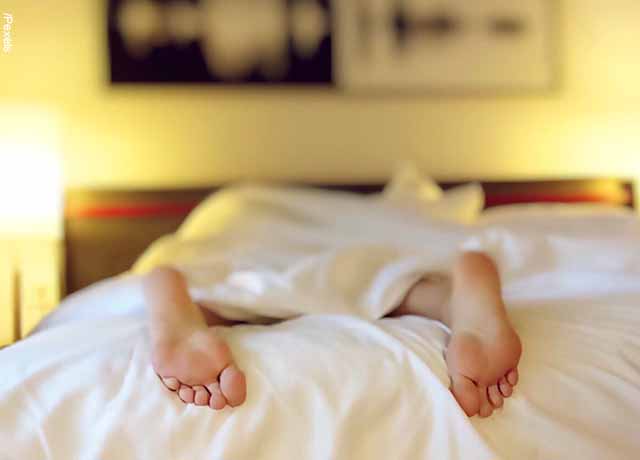 Foto de una persona sobre la cama y solo se le ven los pies
