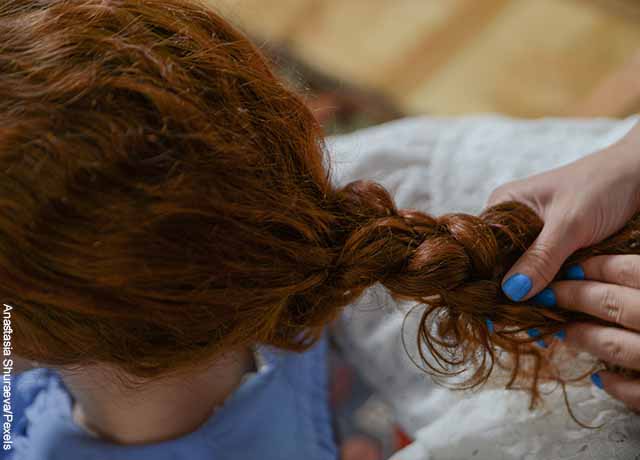 Foto del cabello de una joven al que le hacen una trenza que muestra los masajes para el cabello