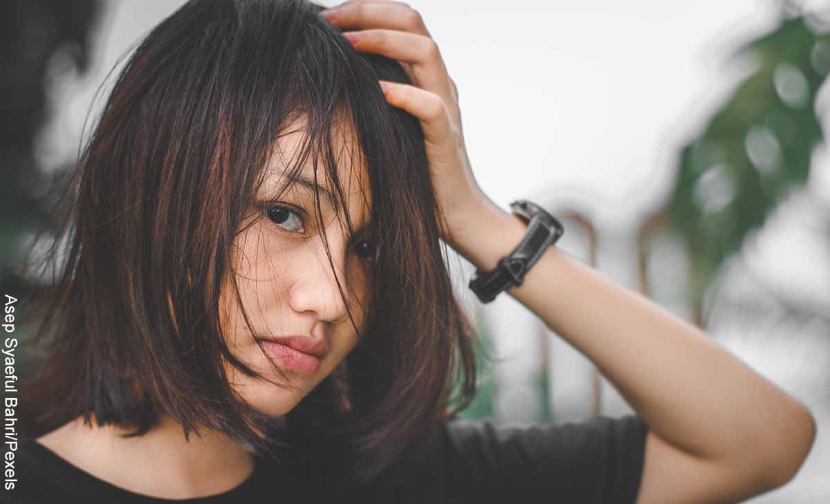 Foto de una mujer asiática cogiendo su pelo que revela los masajes para el cabello