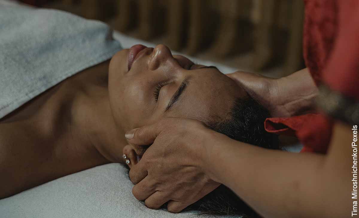 Foto de una persona masajeando la cabeza de una mujer que muestra los masajes para el dolor de cabeza