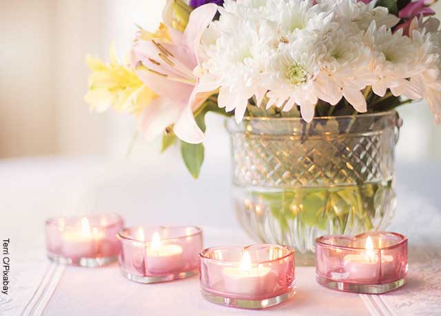 Foto de velas rosadas encendidas con flores
