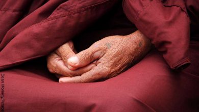 Foto de las manos de un monje orando que muestra los mantras poderosos