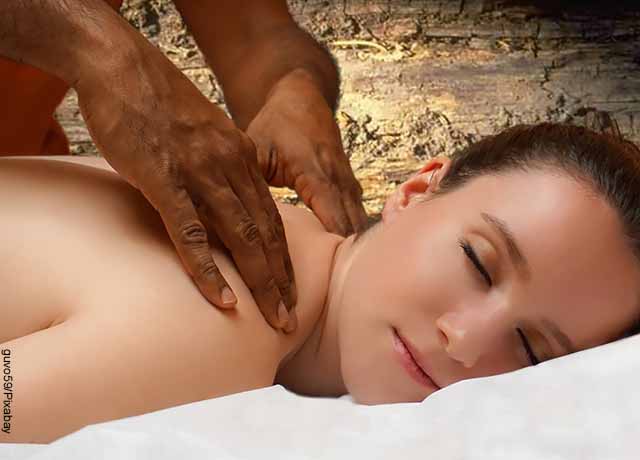 Foto de una mujer acostada boca abajo que recibe un masaje