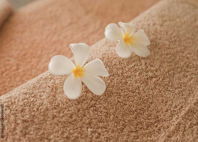 Foto de una toalla con dos flores encima que muestra el masaje nuru
