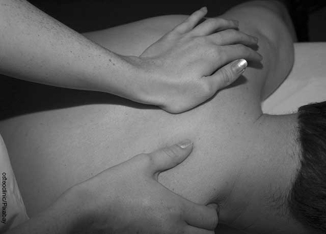 Foto de un hombre al que le dan un masaje en su espalda
