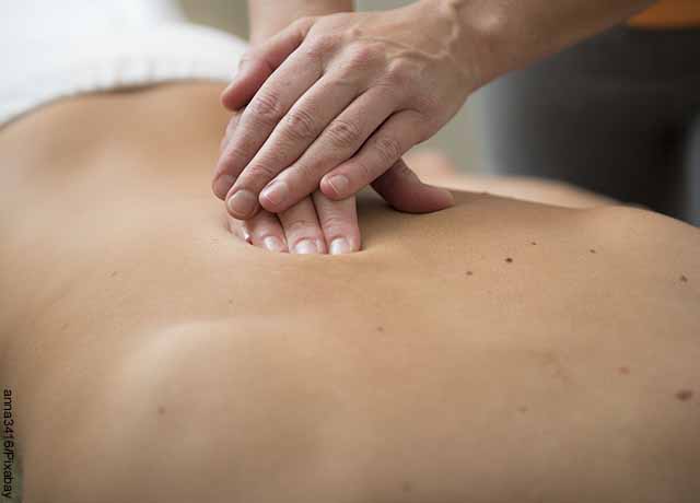 Foto de una persona a la que le practican un masaje en la espalda baja