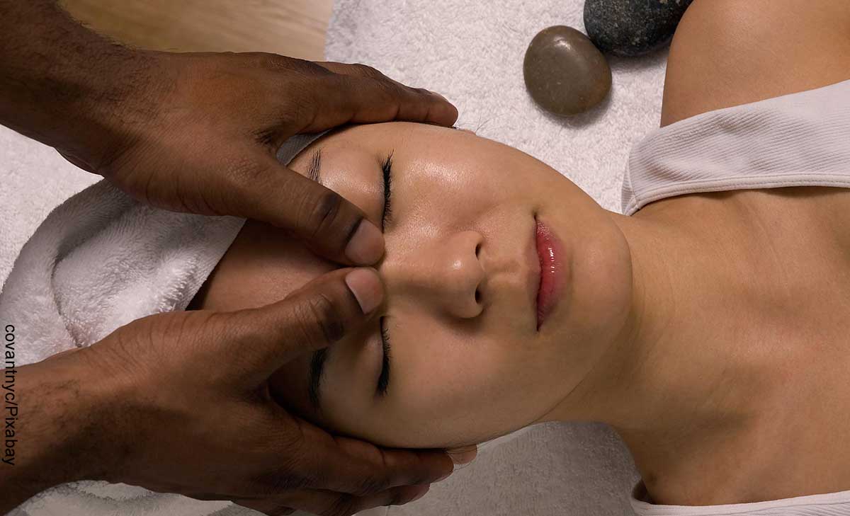 Foto del rostro de una mujer a la que le están tocando la frente que muestra los masajes asiáticos
