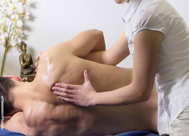 Foto de una masajista tocando la espalda del paciente que revela los masajes en la espalda