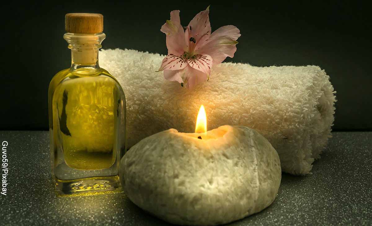 Foto de velas, aceite y toallas que revela los masajes para celulitis