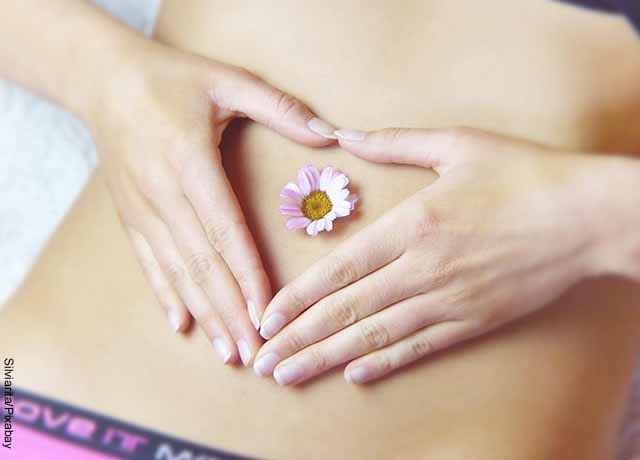 Foto del vientre de una mujer con una flor que muestra los masajes para cólicos