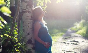 Foto de una mujer embarazada frente a un árbol que revela los masajes para embarazadas