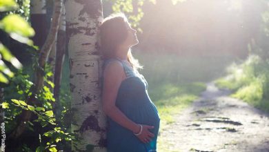 Foto de una mujer embarazada frente a un árbol que revela los masajes para embarazadas