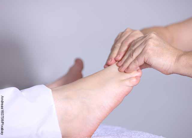 Foto de un terapeuta tocando los pies de un paciente