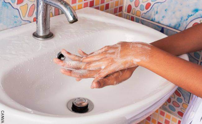 Foto de manos de mujer lavándose en un lavamanos