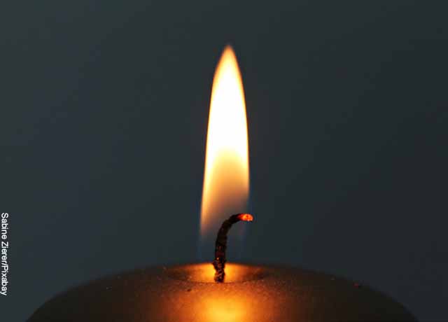 Foto de la mecha de una vela prendida que muestra un ritual de agradecimiento