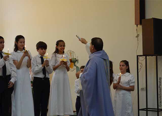Foto de un sacerdote con niños en la iglesia
