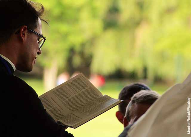 Foto de un sacerdote con una biblia en su mano