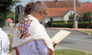 Foto de un sacerdote leyendo la biblia que muestra el ritual de la confirmación