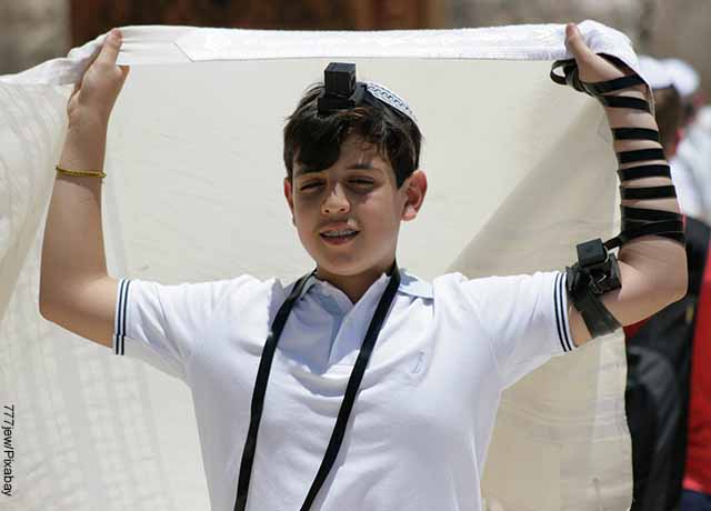 Foto de un joven judío sosteniendo una manta blanca