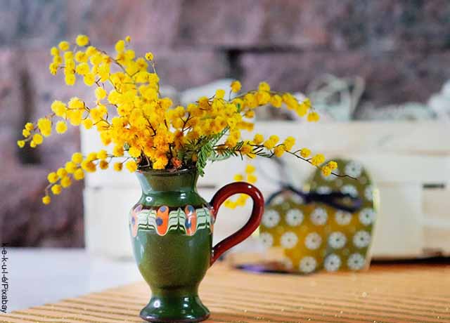 Foto de un jarrón con flores amarillas adentro