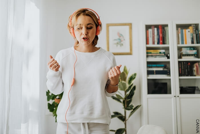 Mujer con audífonos escuchando música para limpiar sus malas energías