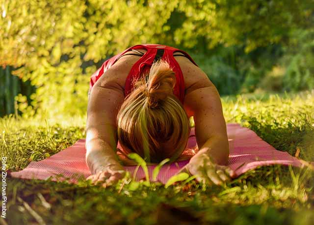 Foto de una mujer acostada haciendo yoga