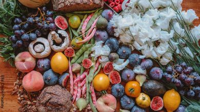Foto de muchas frutas, verduras y flores sobre la mesa que revela el mantra de la abundancia