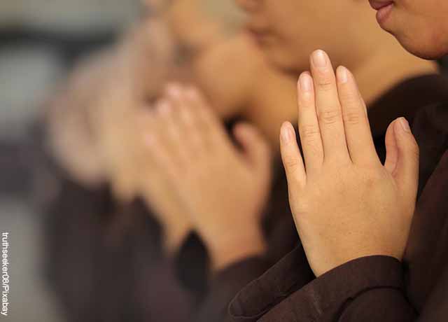 Foto de personas orando con las manos juntas