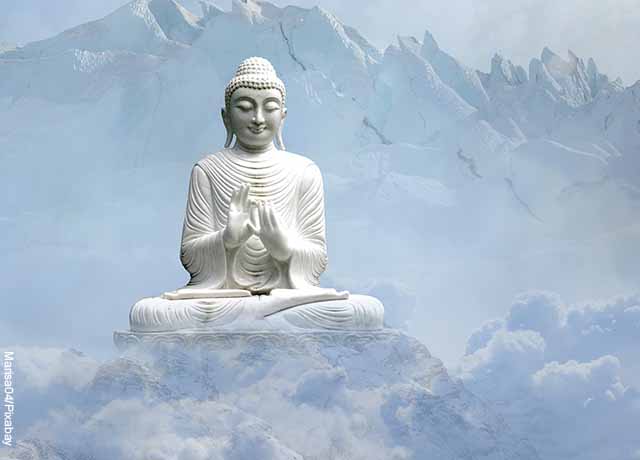 Foto de estatua meditando en una montaña