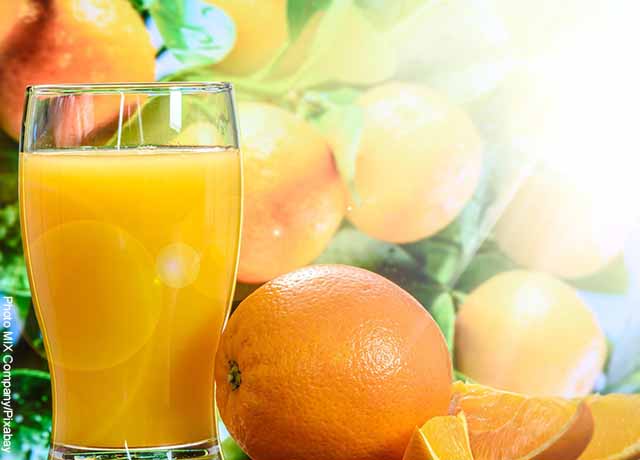 Foto de un vaso de jugo con naranjas al lado que muestra cómo tomar la gelatina sin sabor