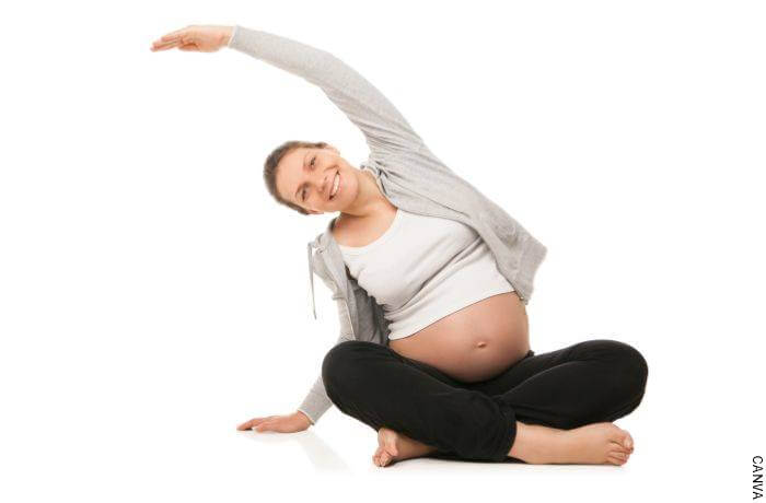 Foto de mujer en estado de embarazo haciendo estiramiento