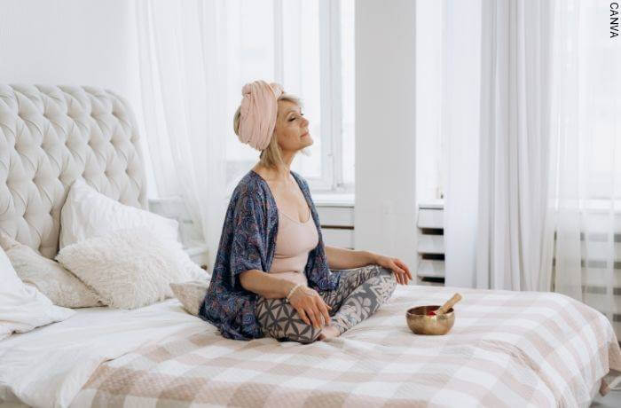 Foto de mujer meditando en la cama