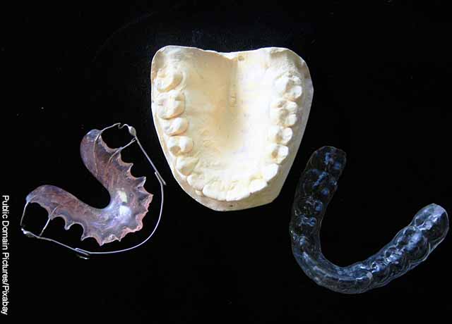 Foto de prótesis dentales sobre una mesa negra