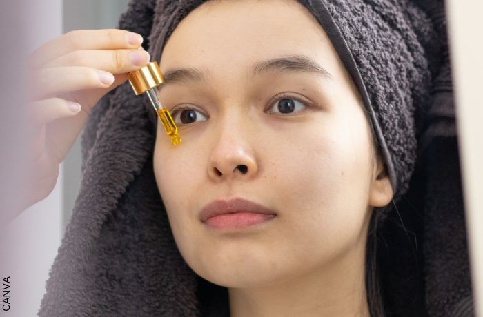 Foto de mujer aplicándose aceite en la cara