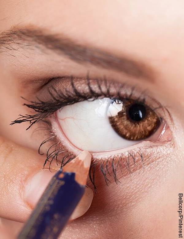 Foto de ojo de mujer aplicándose lápiz de ojos
